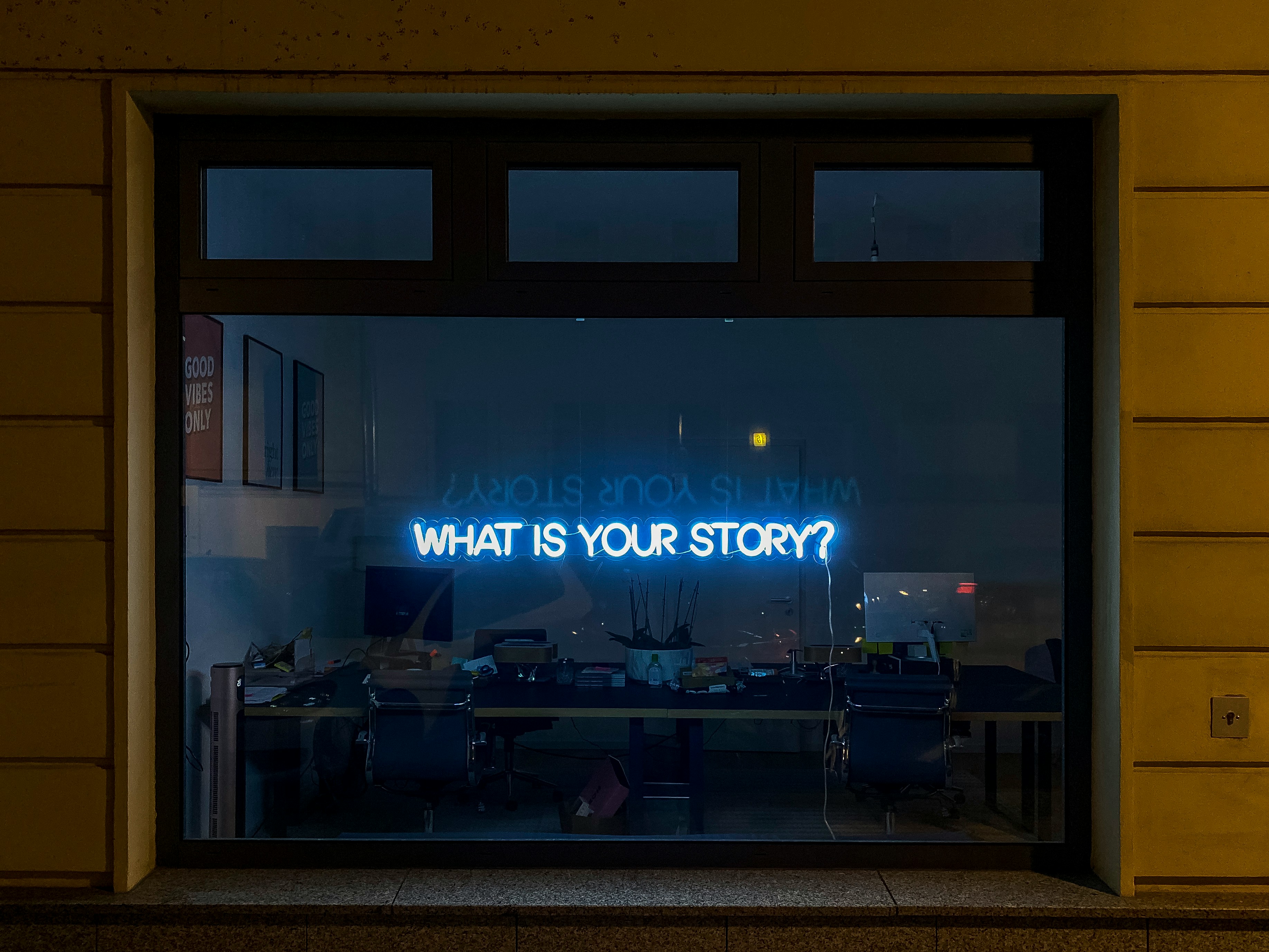 What is your story? - Neon sign in an office window
